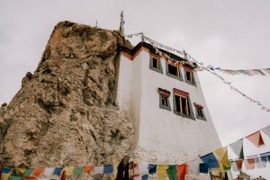 Historic Buddhist monastery and colorful prayer flags in the tranquil Himalayas of Himachal Pradesh, India.